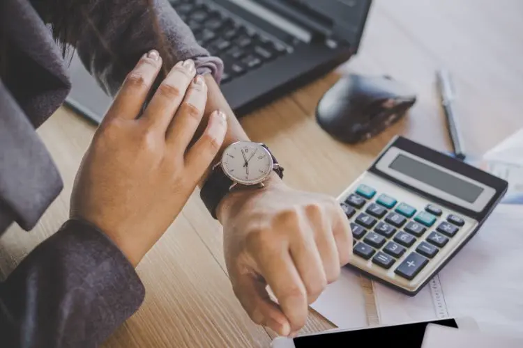 Femme regardant sa montre sur son poignet au travail
