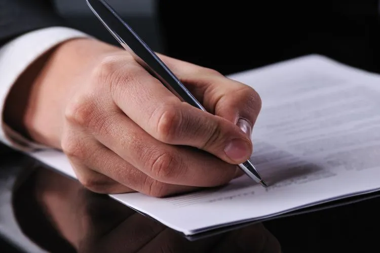 Un homme signe le contrat pour le rachat d'une entreprise pour 1 euro
