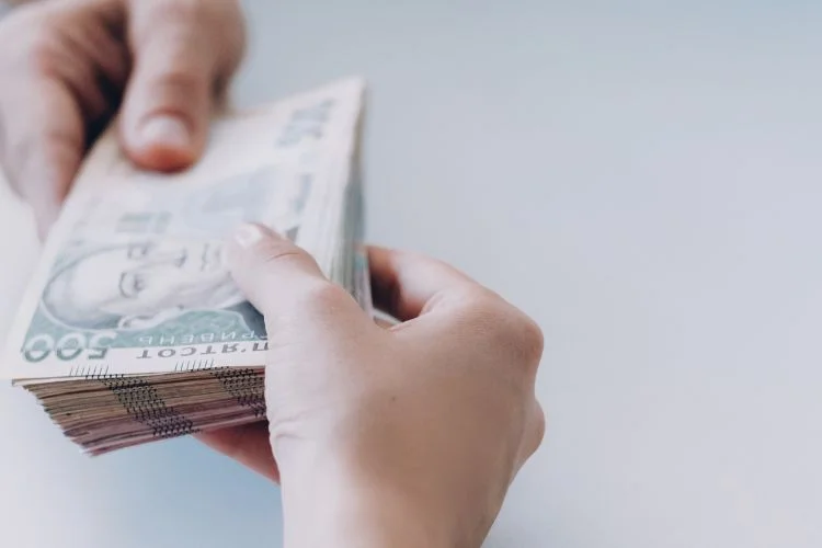 Des liasses de billet échangées entre deux personnes