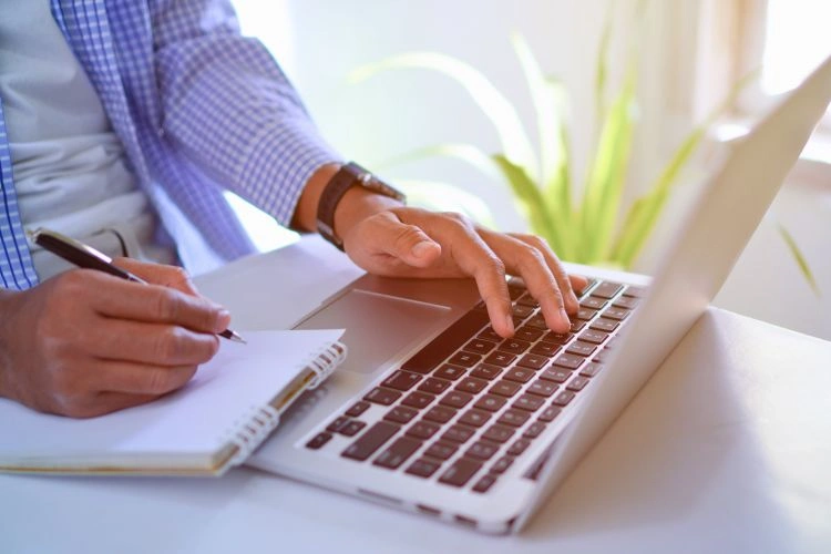 Homme écrivant sa lettre de motivation avec l'IA