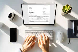 Auto-entrepreneur saisissant une facture sur un outil en ligne